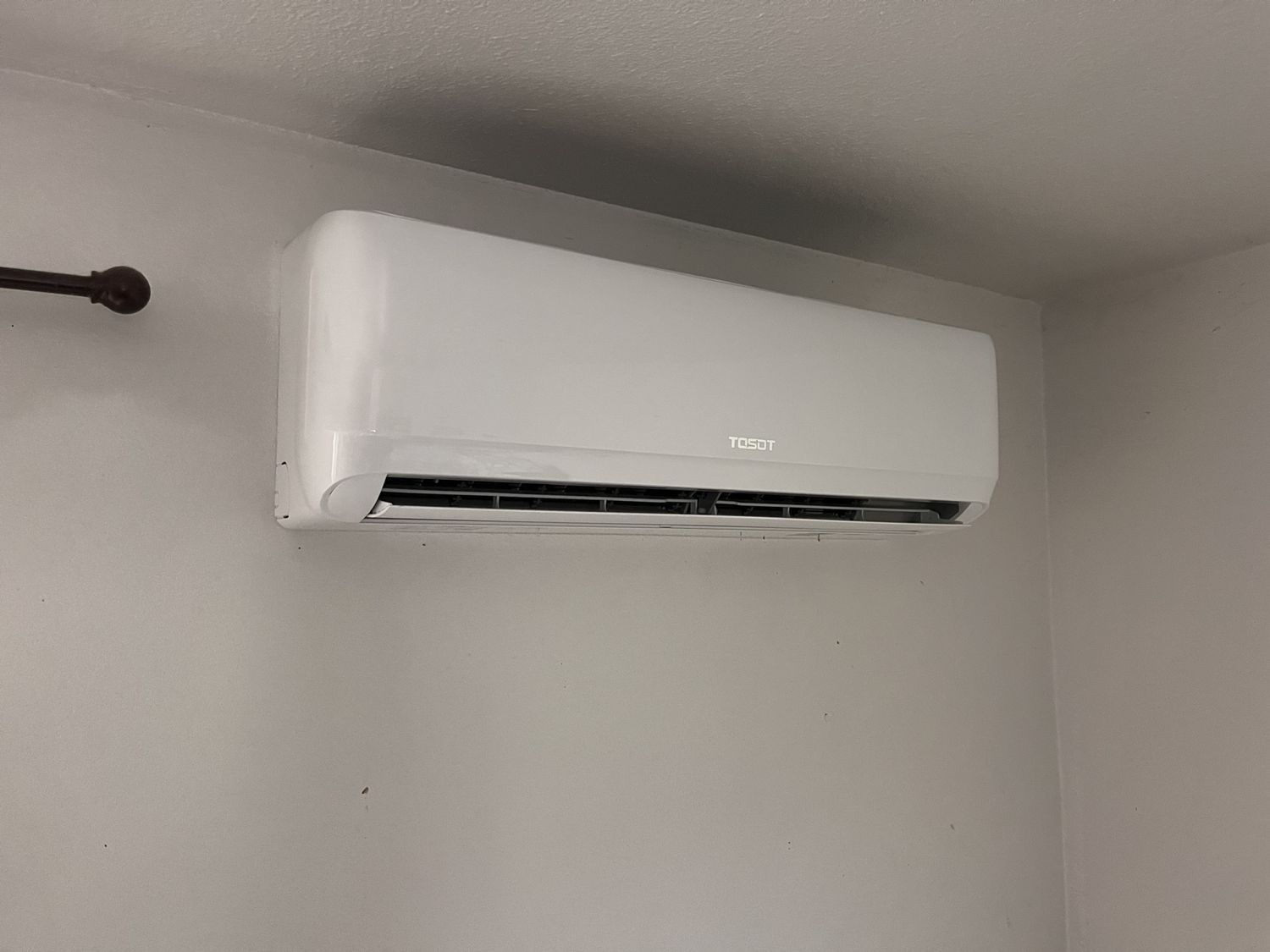 Clean ductless AC condenser installed on a pad outside a Pomona home