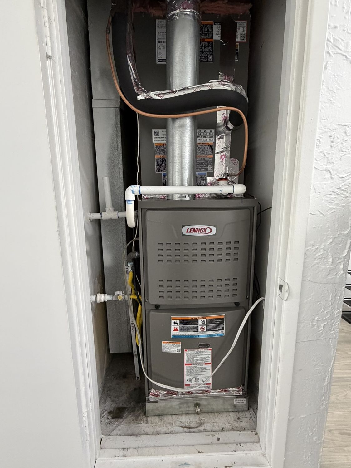 Lennox gas furnace installed in a closet with clean piping